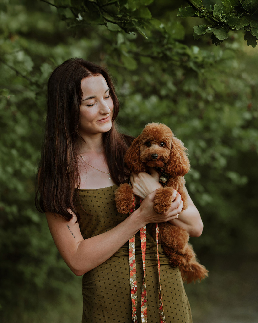 portret autorki sklepu z pudelkiem na tle drzewa